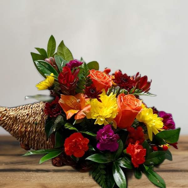 Colorful mixed flower bouquet in a woven cone holder
