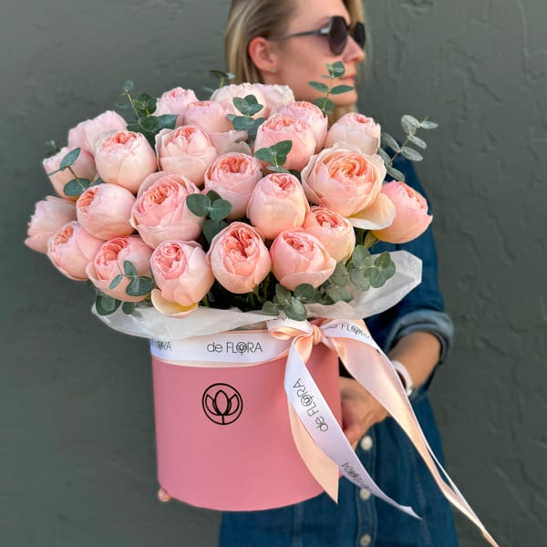 Pink roses in a round pink box with a ribbon