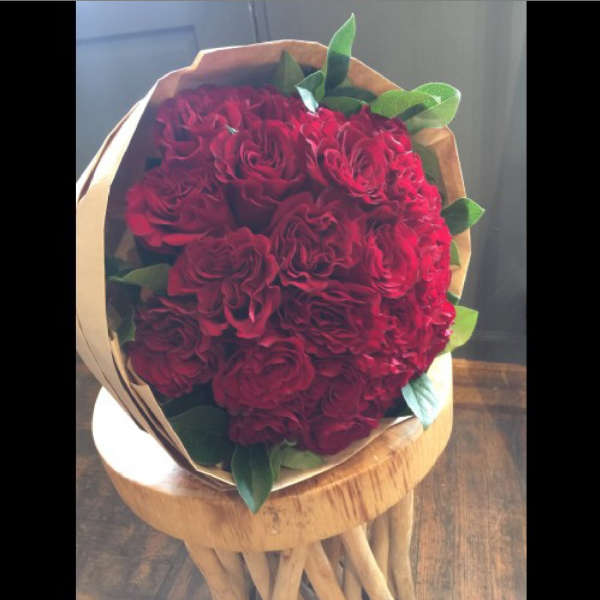 Bouquet of red roses wrapped in brown paper