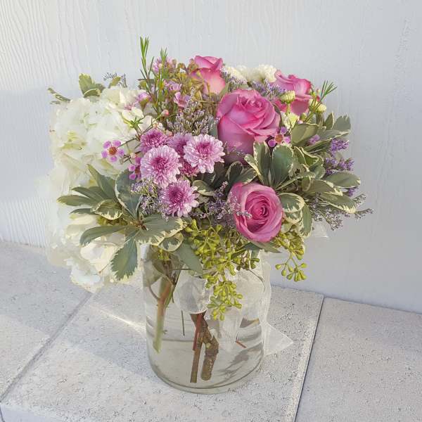 Pink roses and white hydrangeas in a clear glass vase