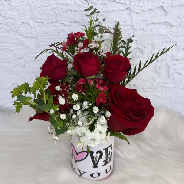 Red roses and white filler flowers in a printed vase