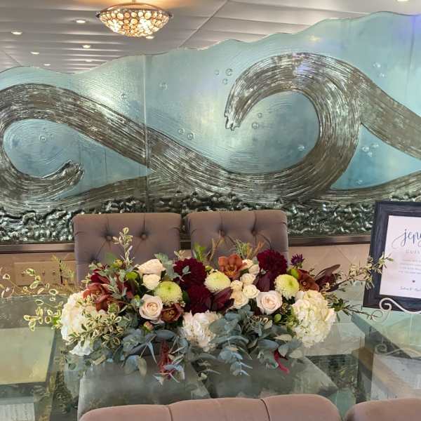 Low floral centerpiece with roses and mums on a table