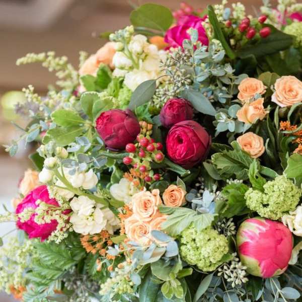 Bouquet of pink and peach flowers with mixed greenery