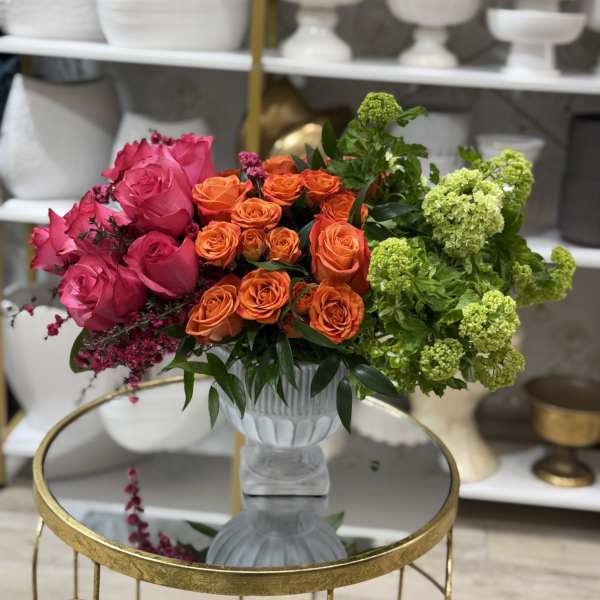 Bouquet of pink, orange, and green roses in a white vase