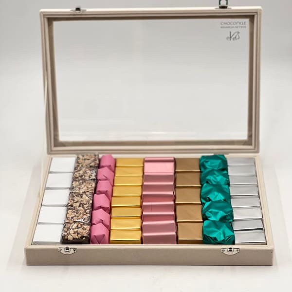 Open gift box with assorted wrapped chocolates in neat rows