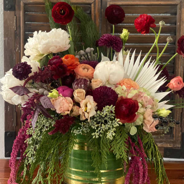 Mixed bouquet in a green-and-gold vase with red, white, and purple flowers