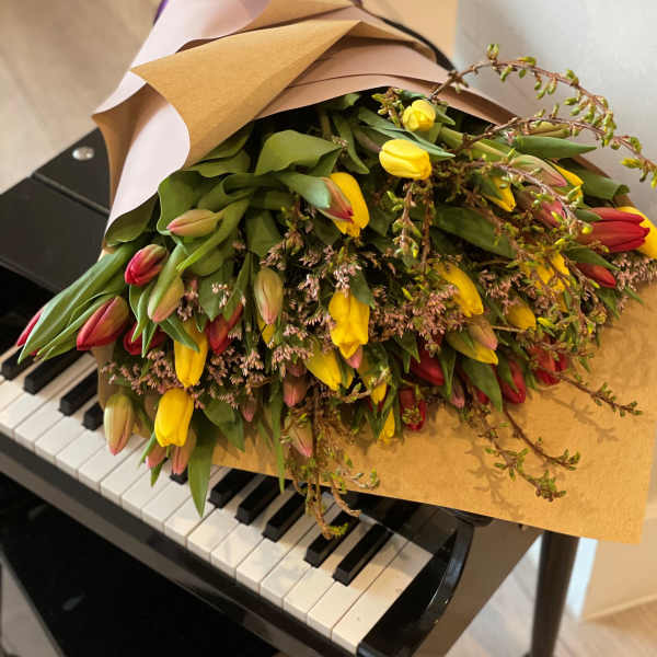 Bouquet of yellow and red tulips wrapped in brown paper