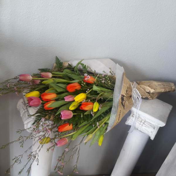 Bouquet of multicolored tulips wrapped in paper