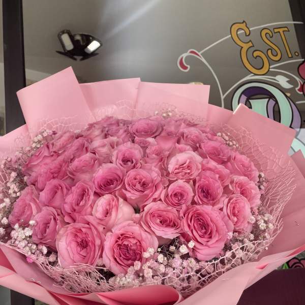 Large bouquet of pink roses wrapped in pink paper