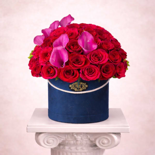 Red rose arrangement with pink calla lilies in a blue hatbox