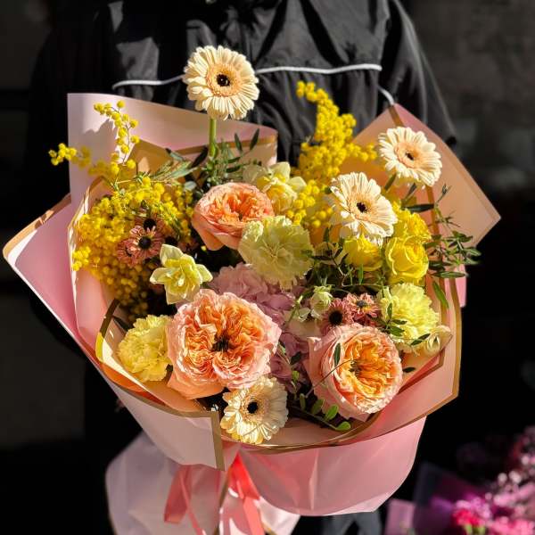 Pink and yellow bouquet with gerbera daisies and carnations wrapped in pastel paper