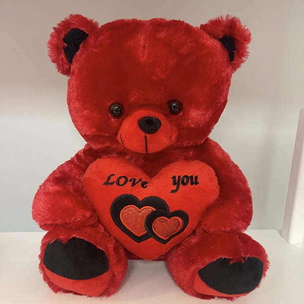 Red teddy bear holding a heart that says "Love you"
