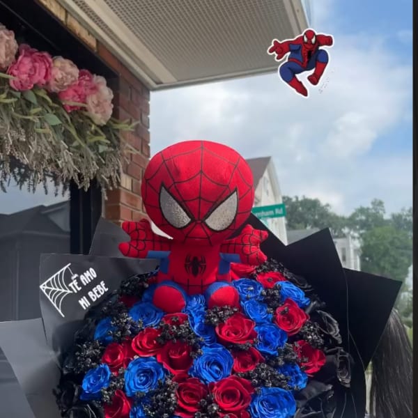 Spider-Man plush atop a bouquet of red and blue roses