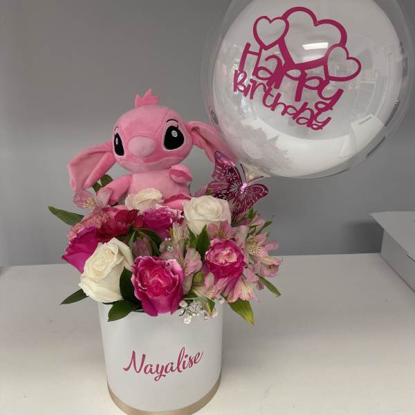Pink plush toy with roses in a white box and a clear birthday balloon