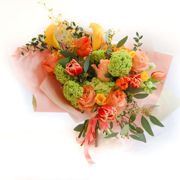 Bouquet of orange and yellow flowers wrapped in pink paper