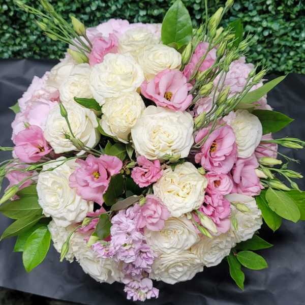 Bouquet of white and pink roses with green foliage