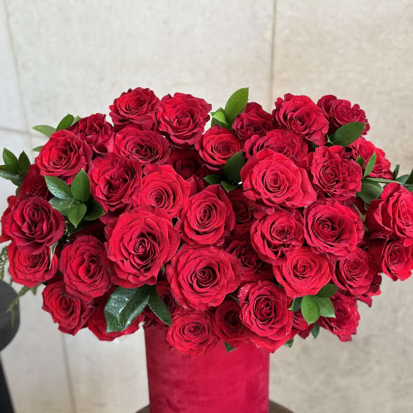 Red rose bouquet in a pink cylindrical vase