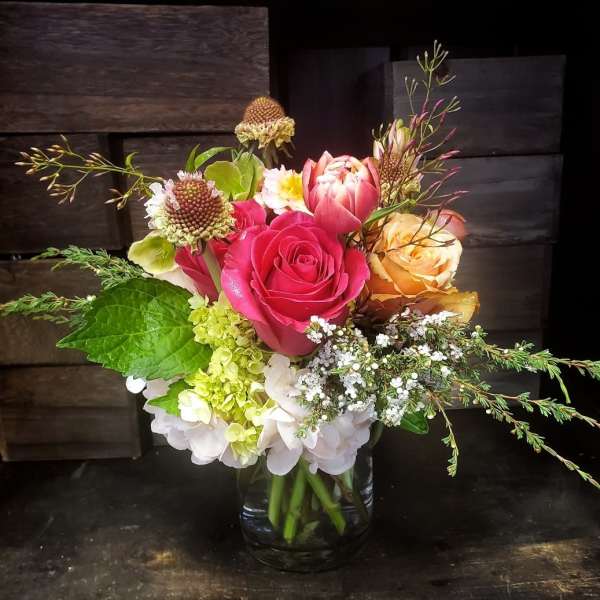 Mixed bouquet of pink and peach roses in a glass vase