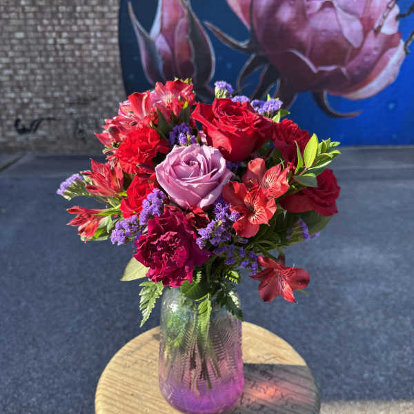 Bouquet of red and lavender roses in a glass vase