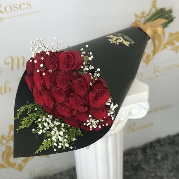 Bouquet of red roses with baby's breath in black wrap
