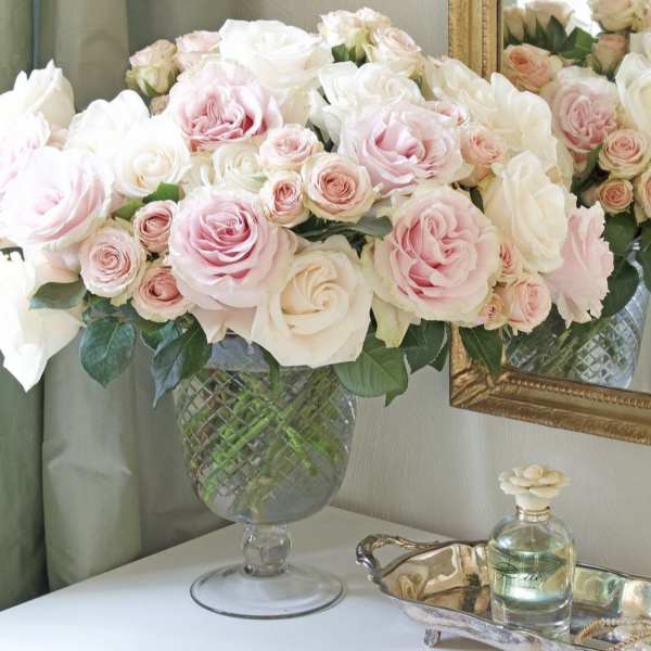 Pink and white roses arranged in a clear glass vase