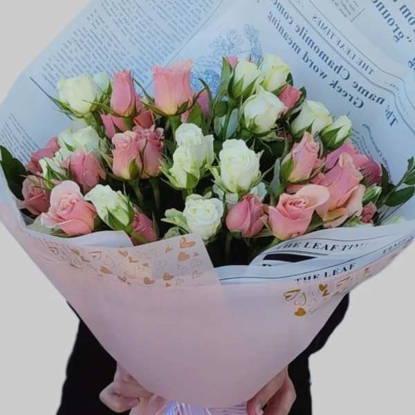 Bouquet of pink and white roses wrapped in pastel paper