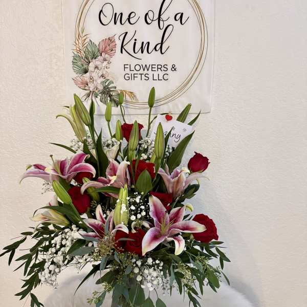 Bouquet of pink lilies and red roses in a glass vase