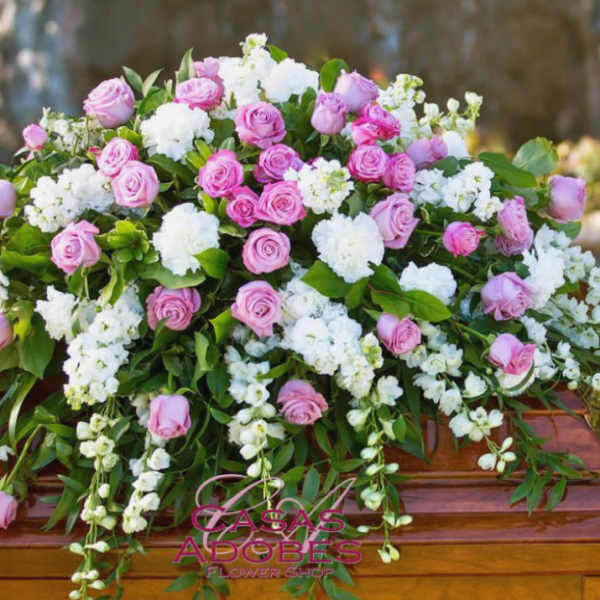 Pink and white floral casket spray with roses and carnations