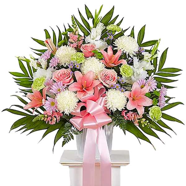 Pink and white floral spray in a vase with a pink ribbon