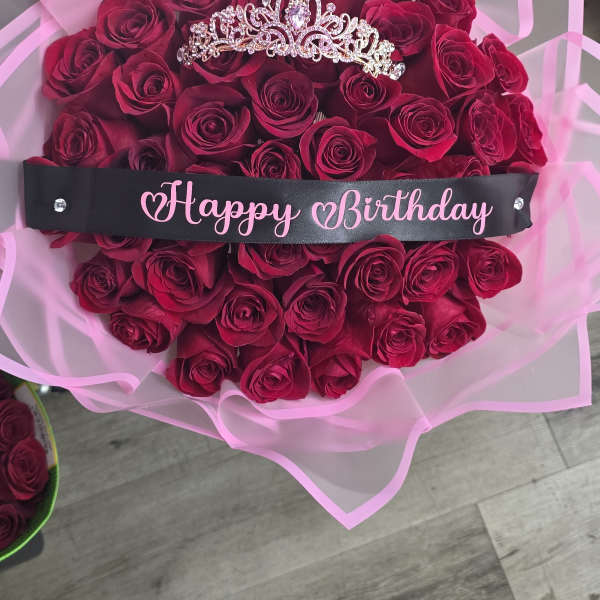 Bouquet of deep pink roses with a jeweled tiara and Happy Birthday ribbon