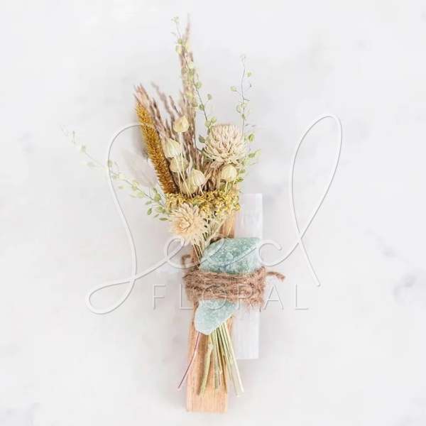 Dried floral bouquet with pale blooms and grasses tied with twine