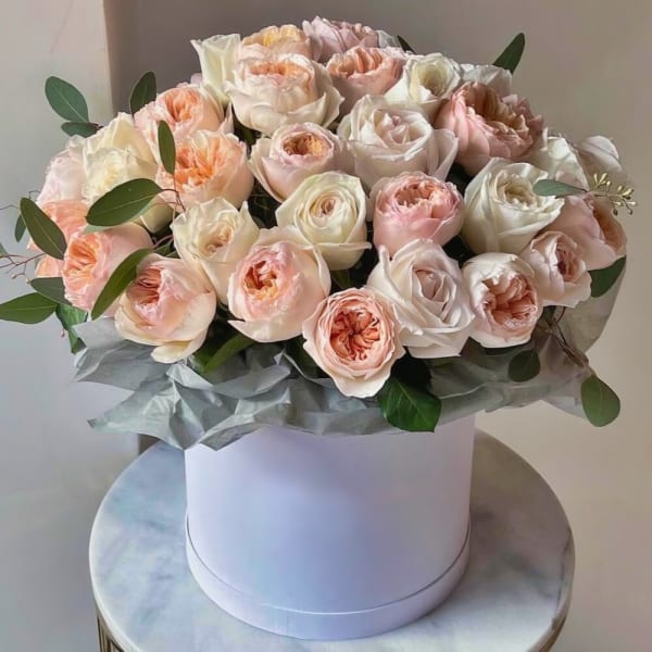 Bouquet of blush and white roses in a white hat box