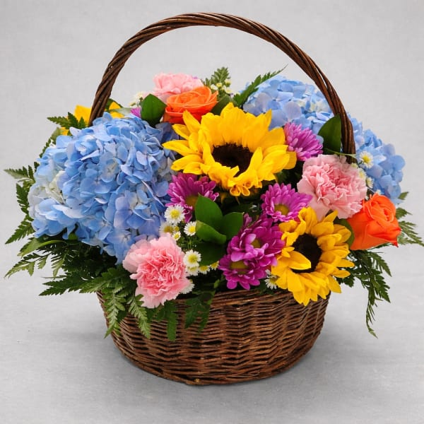 Basket of mixed flowers with sunflowers, hydrangeas, roses, and carnations