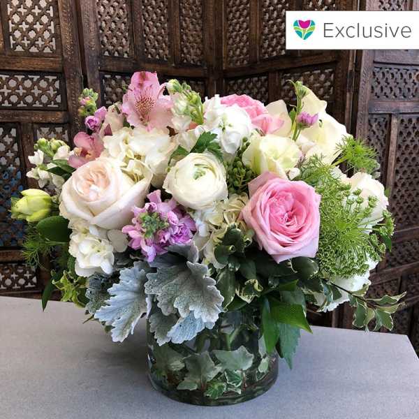 Pink and white mixed flower arrangement in a glass vase