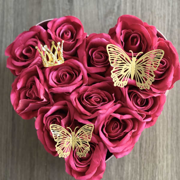 Heart-shaped bouquet of pink roses with gold butterfly and crown decorations