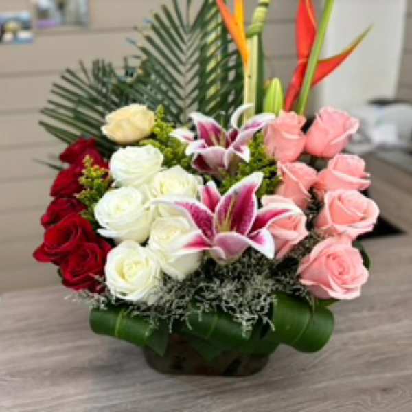 Arrangement of roses and lilies in a low basket