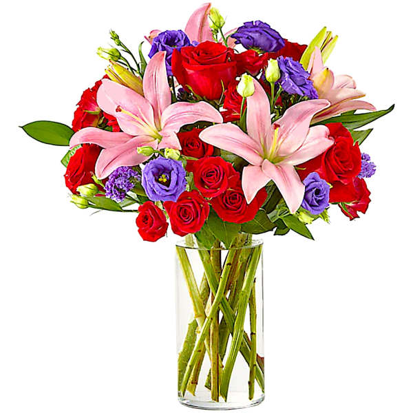 Bouquet of red roses, pink lilies, and purple flowers in a clear glass vase