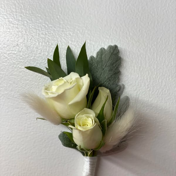 Small white rose boutonniere with gray foliage and soft feather accents