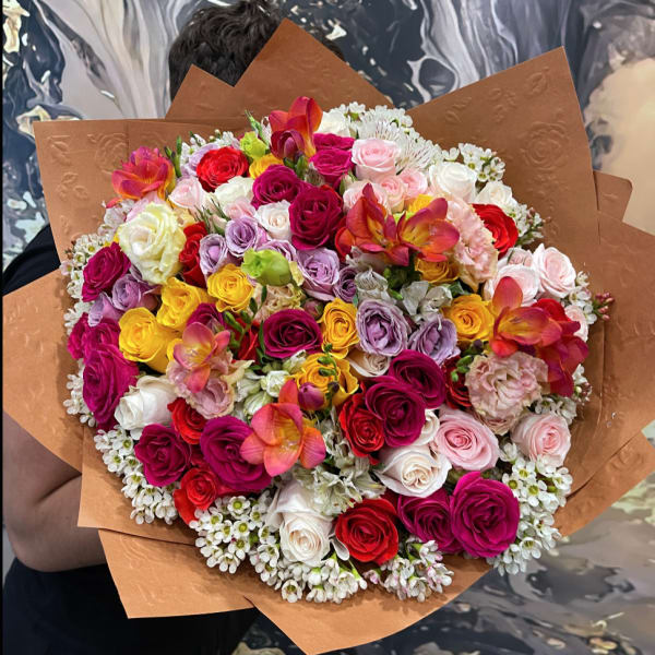 Large bouquet of multicolored roses with brown paper wrapping