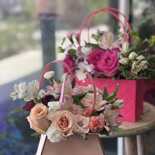 Pink and peach flower baskets with roses and alstroemeria
