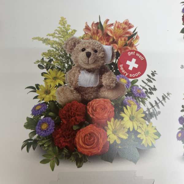 Teddy bear in a colorful flower arrangement with a get well sign