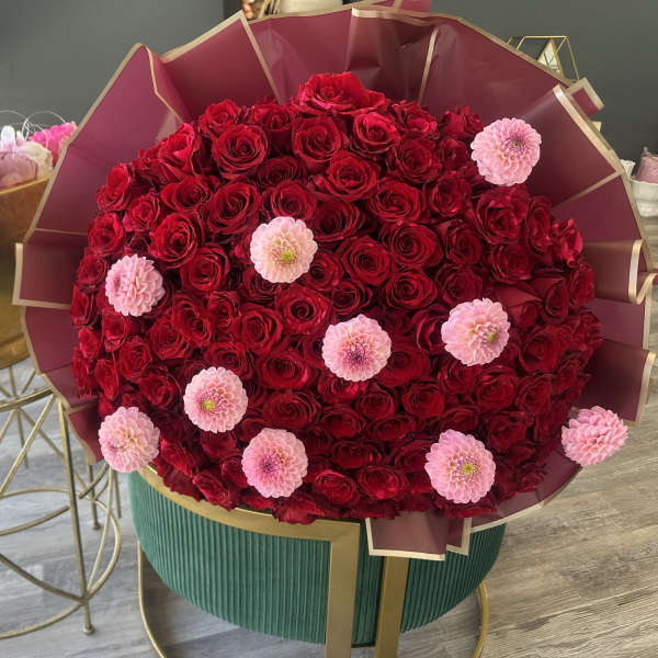 Large bouquet of red roses with pink flowers in burgundy wrap