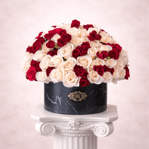 Red and white roses arranged in a black round box