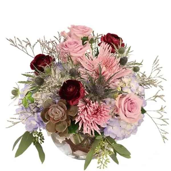 Mixed bouquet of pink and burgundy flowers in a glass vase
