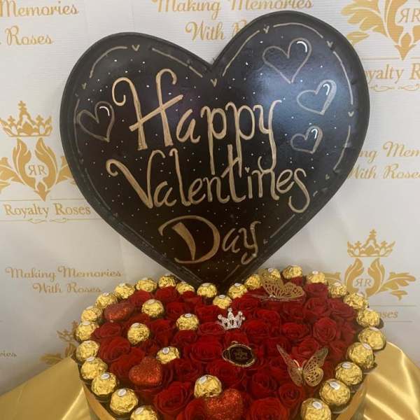 Heart-shaped rose arrangement with chocolates and a Happy Valentines Day sign