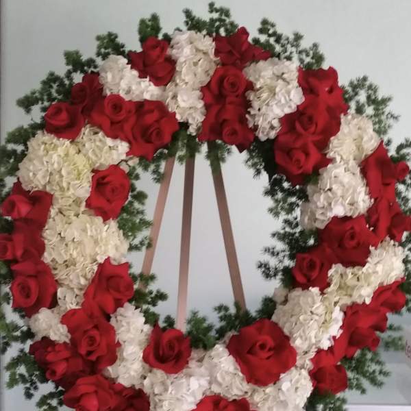 Large wreath of red roses and white hydrangeas on an easel