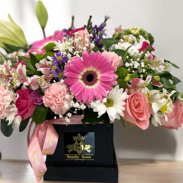 Mixed pink and white flowers in a black gift box with a pink ribbon