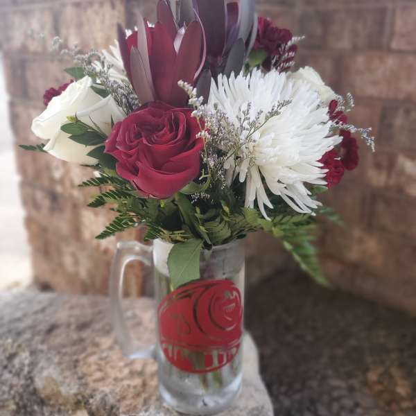 Bouquet of red and white roses with white chrysanthemum in a glass mug