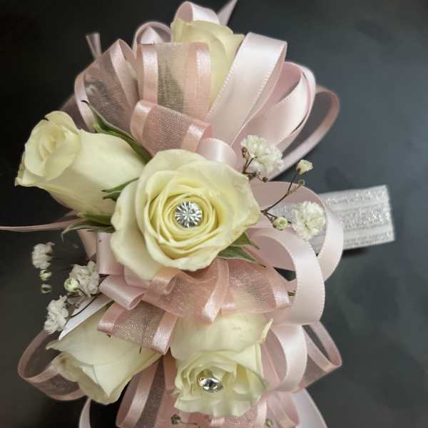 Cream roses with pink ribbon loops and small white filler flowers