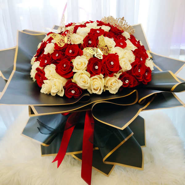 Bouquet of red and white roses with gold butterfly accents